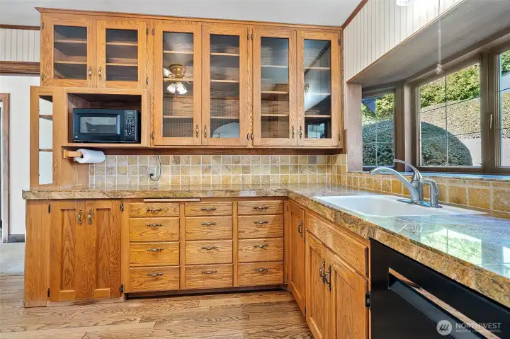 Ample kitchen storage including glass-fronted upper cabinets