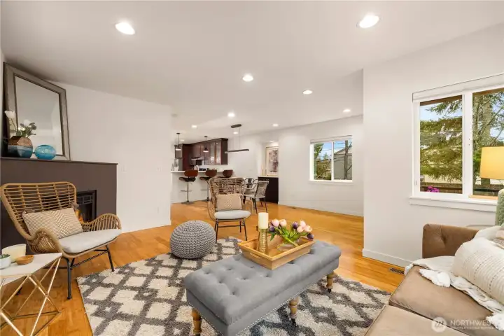 Open floor plan on the main level with gas fireplace, dining area, and kitchen bar seating.