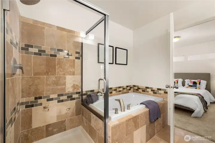 Separate shower and jetted tub in the primary ensuite bath.