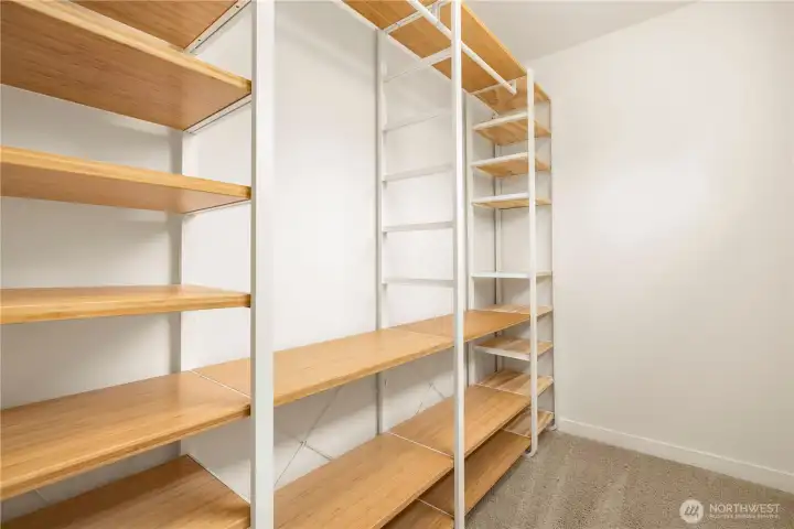 Walk in closet has custom storage built in.