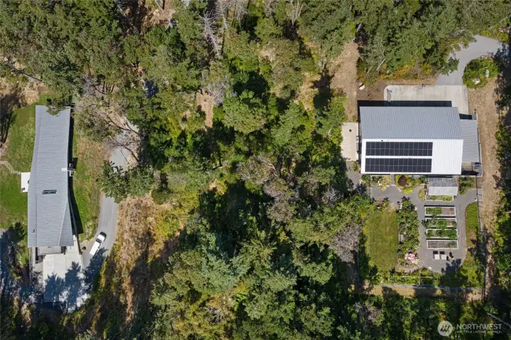 Bird’s-eye view of the estate’s greenhouse, fenced garden beds, and workshop/garage, thoughtfully designed for those seeking luxury San Juan Island living with sustainability and garden-to-table lifestyle.