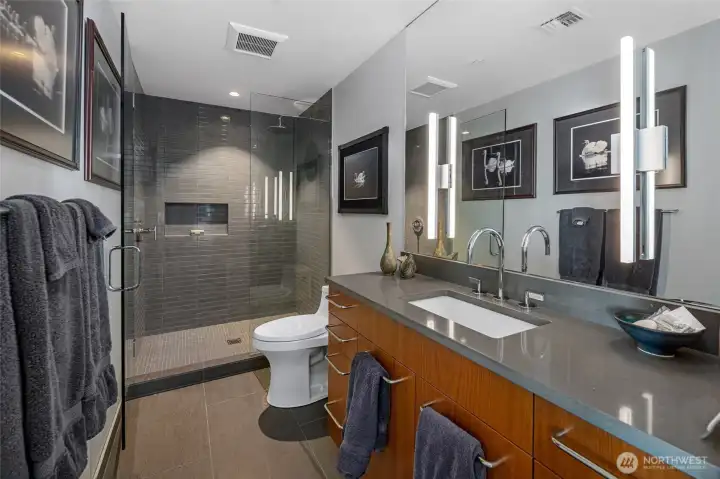 Modern spa-like bathroom featuring sleek countertops, dual sinks, and an elegant walk-in tile shower designed for both comfort and style.