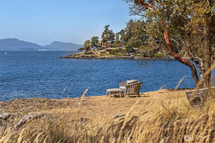 A peaceful seating area set near the shoreline invites quiet moments overlooking San Juan Island’s rugged coastline and expansive open water.