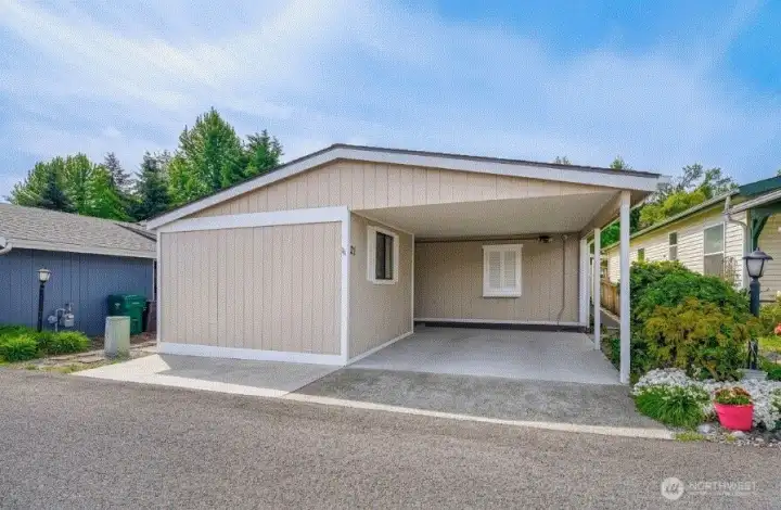 Covered carport entry with easy access and low-maintenance exterior—welcome to comfortable 55+ living.