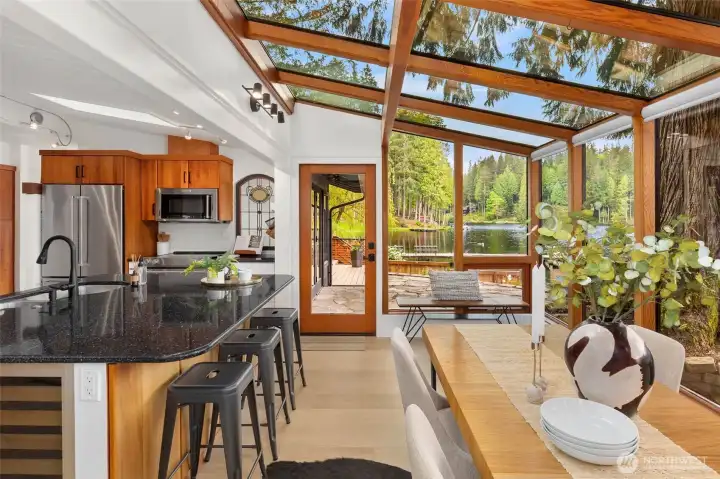 Open kitchen wrapped in atrium-style windows with electric blind for the sunny days.