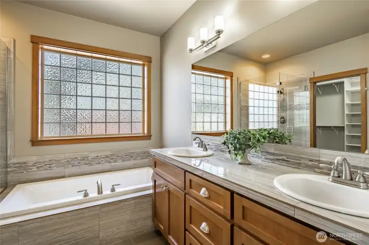 Primary spa-inspired bath with tiled shower and soaking tub. Primary spa-inspired bath with tiled shower and soaking tub.