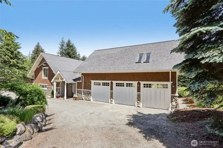 The oversized three-car garage, extensive parking area, and seamless connection to the home's addition and upper-level primary suite.