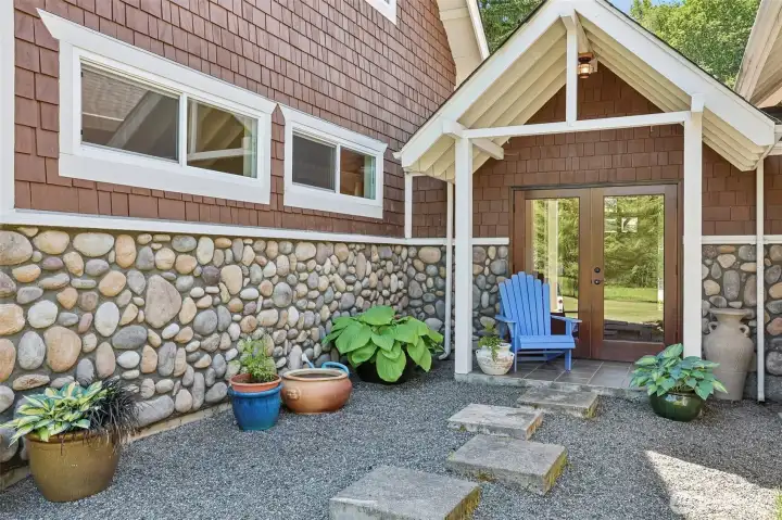 A warm and welcoming rear entrance opens to expansive outdoor living spaces.
