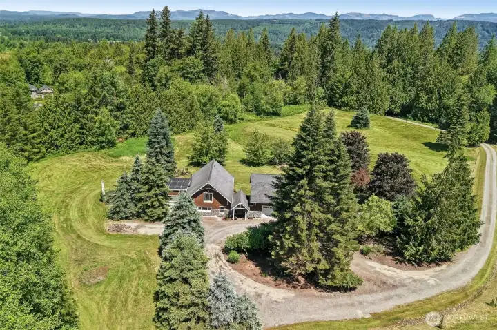 Aerial view showcases the private gated estate surrounded by open pastures.