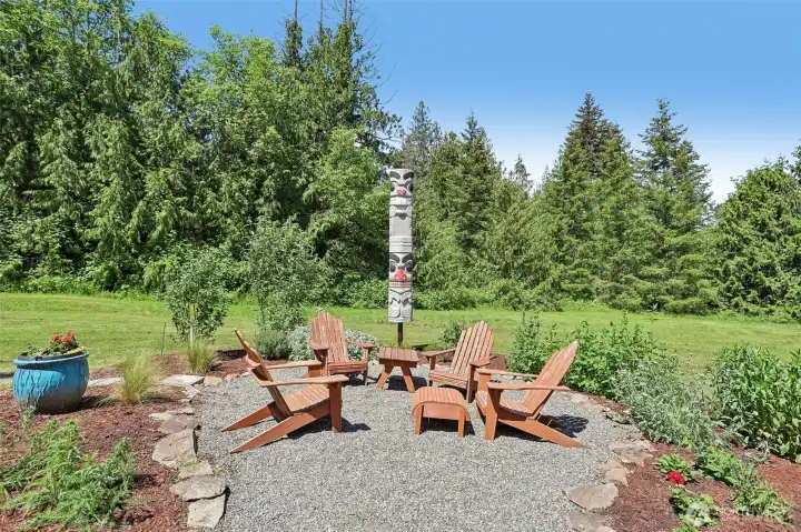 Gather with family and friends in this charming outdoor seating area, highlighted by the property's iconic totem pole and peaceful natural surroundings.
