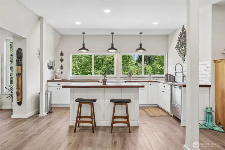 The beautifully updated kitchen features a large center island, abundant cabinetry, and an open-concept design ideal for gathering and entertaining.
