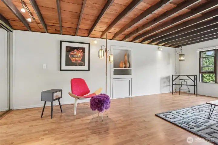 The oversized bedroom offers a peaceful setting with rustic character, open space, and flexibility for additional furnishings or a private sitting area.