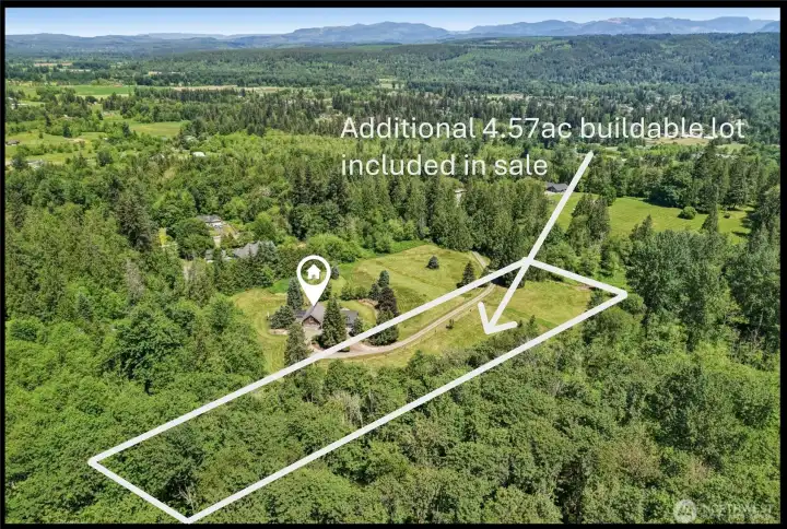 Aerial view highlights the private gated estate nestled among mature evergreens, with the additional 4.57-acre parcel included in the sale outlined for reference.