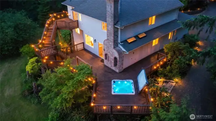 Amazing wraparound deck allows for full enjoyment of the property and views, complete with sunken hot tub, custom fireplace masonry, private en suite level above and stone steps to beautiful and lush paver patio below.