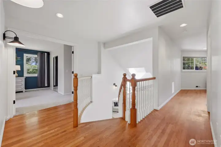 Upstairs the wood floors on this open landing gleam, creating such a beautiful space! The conservatory/office room is seen ahead, but first--the primary bedroom on the left...