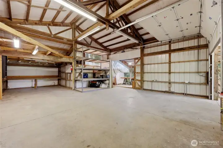 Inside of the enormous shop, with sliding door out to the carport side.