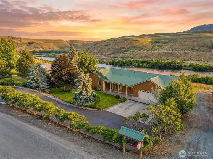 Experience waterfront living at its finest in Pateros, WA. This meticulously maintained rambler sits just steps from the Methow River, offering unmatched privacy, mature landscaping, and sweeping views of Billy Goat Mountain. Looking SE from NW corner of the property.  Photo is Virtually Staged.