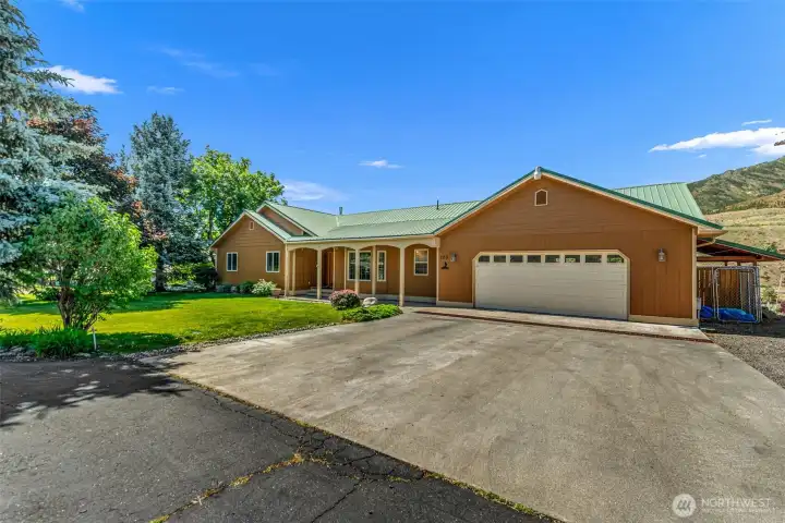 The property features a freshly painted exterior, a large paved driveway offering ample parking for guests, RVs, toys, an attached two-car garage, and a sprawling, maturely landscaped yard complete with an integrated irrigation and sprinkler system.