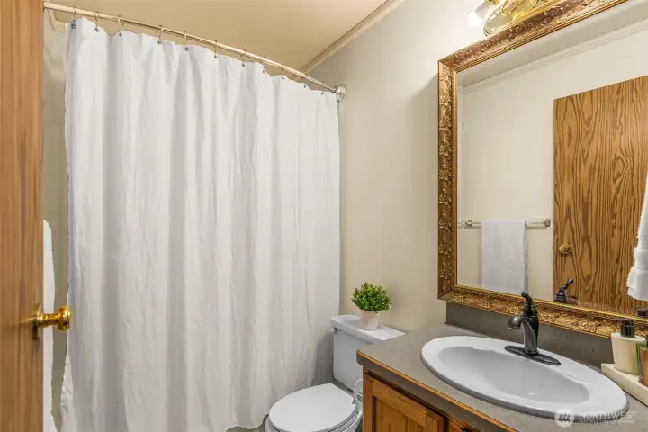Thoughtful design meets everyday convenience! Perfectly situated at the end of the hallway between the primary bedroom and Bedroom 2 on the East end of the home. This full bathroom is easily accessible for both family and guests. Its strategic placement highlights the highly functional, single-level layout