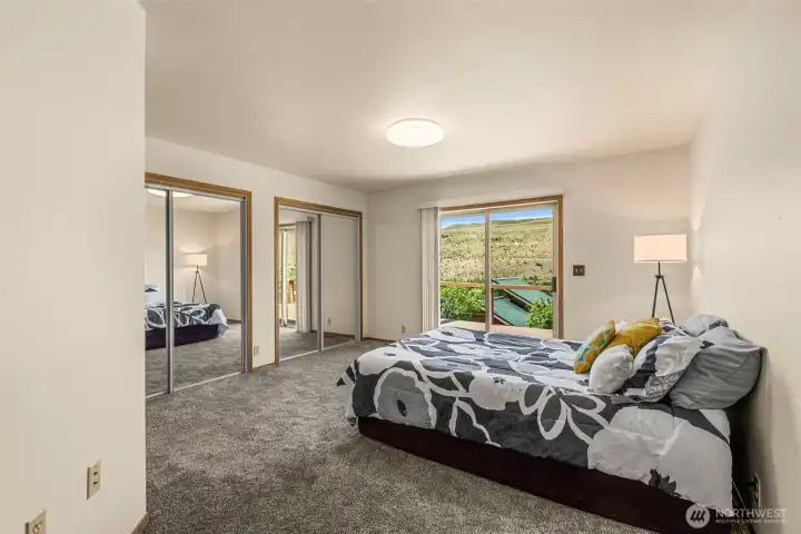 The spacious primary bedroom located on the SE end of the home features two large closets and direct access to the expansive deck. Wake up every morning to amazing, unobstructed views of the meticulously maintained backyard and the majestic Methow River.