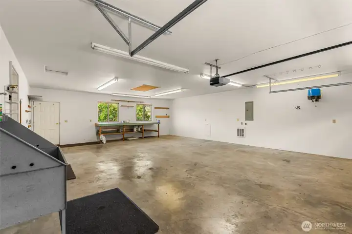 Looking for an oversized garage? This brightly lit, massive attached garage offers incredible flexibility. Complete with a built-in workbench, a utility wash sink, and ample room for parking, extensive storage, a home gym, or a dedicated workshop. It is an absolute dream space for hobbyists and mechanics alike! There is even more storage in the attic space.