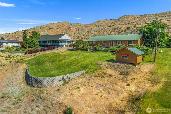 Everyone loves a good "She Shed"! Looking north from the southeast corner of the property, you can see the true scale of this incredible backyard. With a sprawling green lawn, a gorgeous retaining wall, and a dedicated shed ready for your hobbies, this outdoor space is an absolute dream come true.