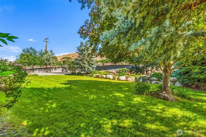 Welcome home! The beautifully manicured front yard features a lush green lawn and gorgeous mature shade trees. Stunning natural rock landscaping completes the incredibly inviting curb appeal.