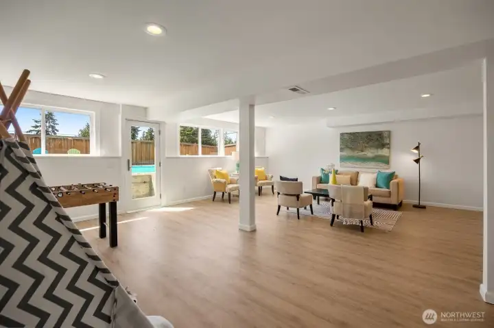 Daylight basement entertainment room with door to the side yard pool/patio area. Daylight basement entertainment room with door to the side yard pool/patio area.