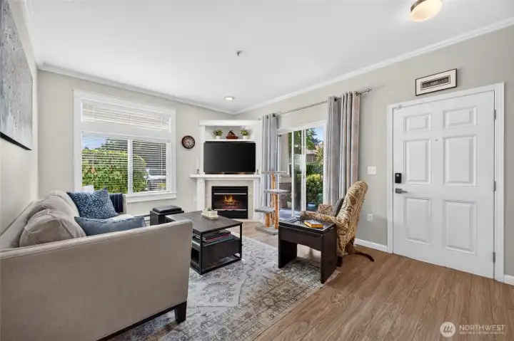 Living room, high ceilings and custom mantel with electric fireplace. Note: The Crown Moldings and  base molding.   Patio is off the living,.only steps to the entry patio.