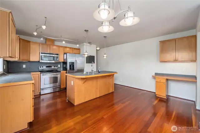 Large-tile counters in the kitchen and on the island, with stainless appliances.  There's even a work/study desk for your convenience. This home is move-in ready, just bring your furniture and personal belongings and then relax in time for summer fun at the pool!