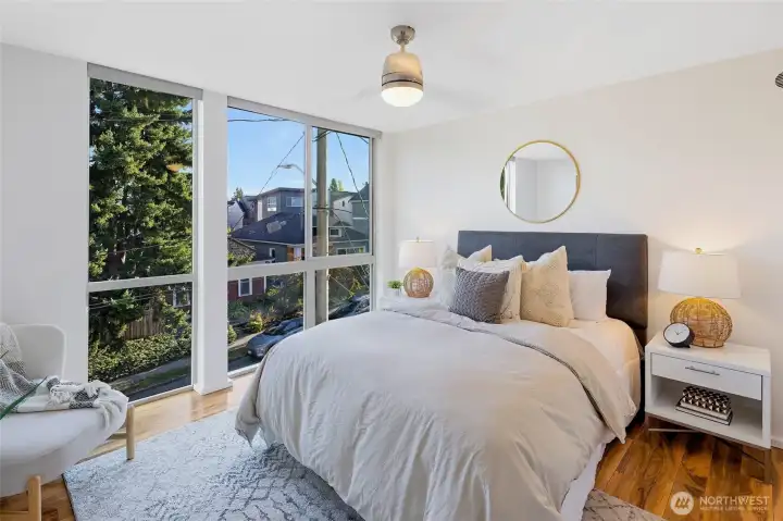 At the end of the hall, the spacious primary suite offers a relaxing retreat with stunning south-facing windows and endless natural light.