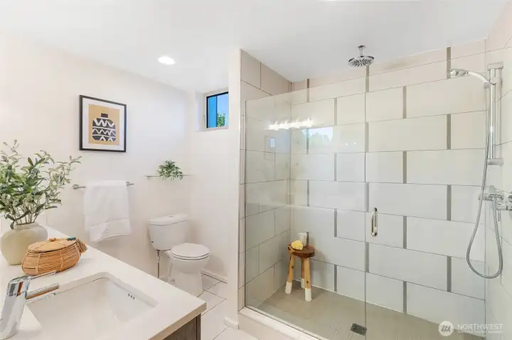 The primary suite’s en-suite ¾ bath offers a spa-like retreat with a rainfall shower—perfect for unwinding after a long day.