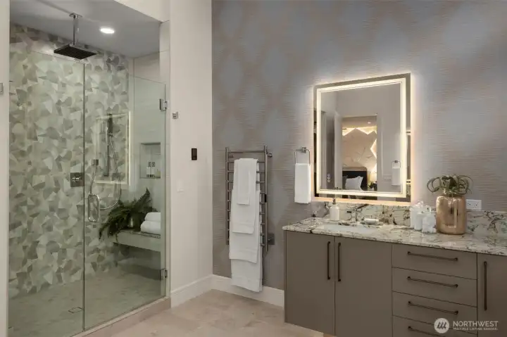 Spa Caliber Primary Shower w/ triple shower heads, hand wand, bench seating & floor-to-ceiling tile surround.