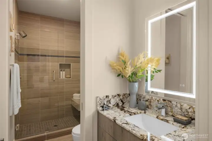Guest Suite Bath w/ Large Shower, Bench Seat, Touch Backlit Mirror & Warm Tones.
