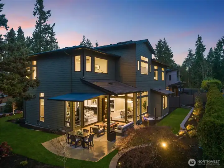 Outdoor Living Oasis w/ Dual Patio Spaces, Powered Retractable Awning & Nighttime Ambiance.