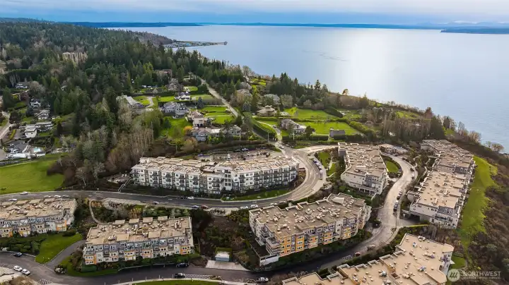 A wide aerial view showcasing the elevated bluffside setting with sweeping neighborhood and hillside views, open sky and the surrounding charm of Edmonds—highlighting how perfectly the home sits within its peaceful, scenic surroundings.