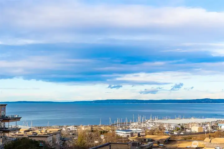 An elevated perspective over the Port of Edmonds captures shimmering water, passing ferries, and the marina below—an ever-changing view that brings the energy of the waterfront right to you.