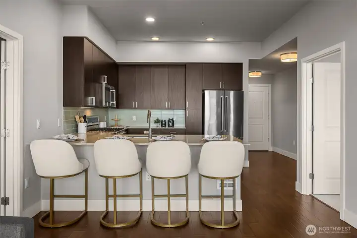 A bright, functional kitchen featuring ample storage with cabinets and pantry space, designed for both everyday cooking and effortless entertaining.