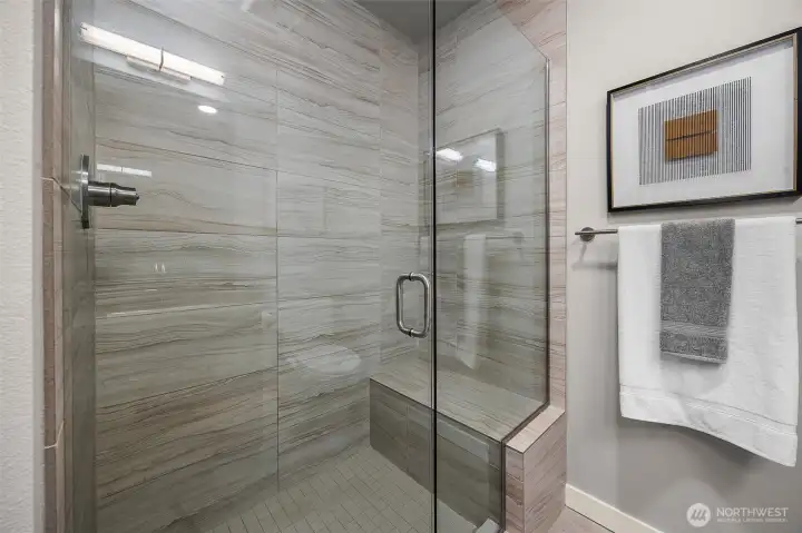 A stunning floor-to-ceiling tiled shower with a sleek, modern design, enhanced by a built-in niche for your bath essentials.
