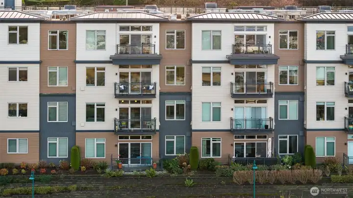 A closer exterior view highlighting the unit itself, showing its private entry, balcony, and architectural details within the beautifully designed complex.