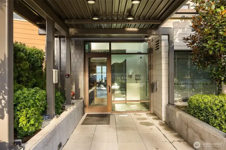 The main entrance to 50 Pine, featuring the sleek modern design, welcoming entryway, and well-maintained landscaping that sets the tone for the luxury within.