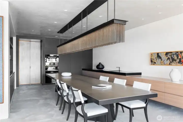 Center island kitchen dining table and work surface... twelve custom leather dining chairs, prep/bar sink to the right. Full size refrigerator and freezer + wine fridge, multiple freezer/fridge drawers and built in Miele espresso machine.