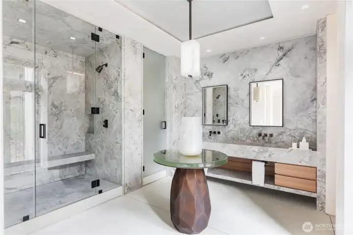 Primary bathroom suite finished in solid Italian Marble, center island table, steam shower.