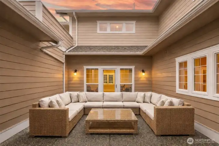 Enclosed entry courtyard creates a private, welcoming outdoor living space, ideal for relaxing or gathering, with direct access to the home. - virtually staged