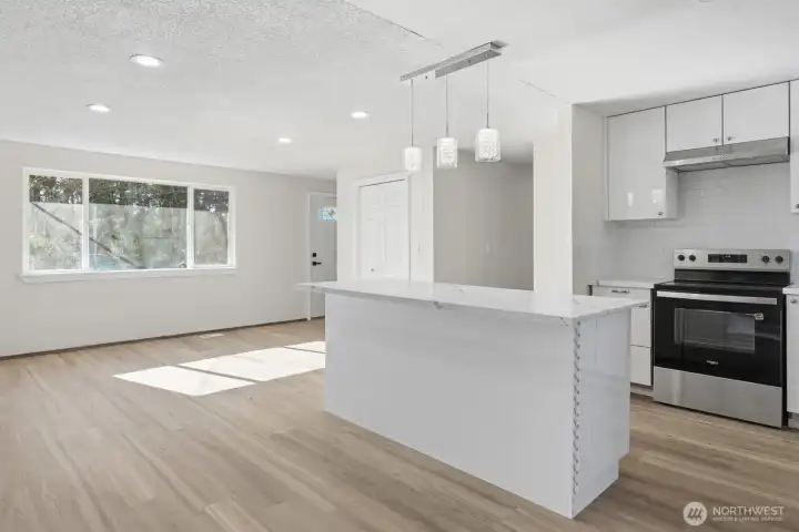 Kitchen offers an island with classy pendant lighting.