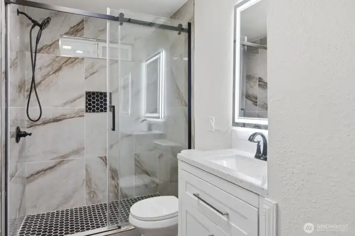 2nd bathroom for added convenience also with a tile shower, new vanity, and lit mirror.