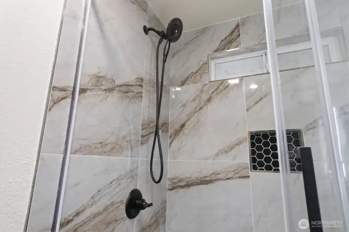close up of the tile souround in the shower and fixtures.