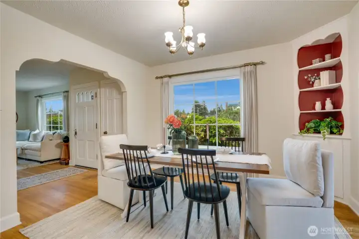 Formal dining room with original built-ins, classic light fixture and Tudor-style interior arch