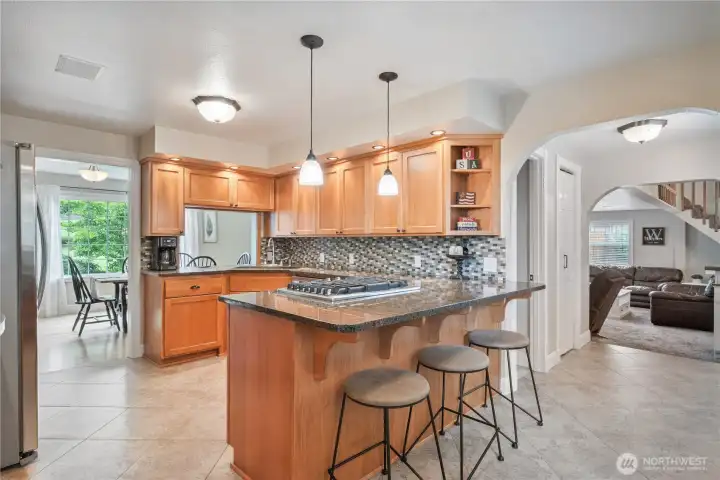 Kitchen with custom wood cabinets, granite countertops, gas range, and stainless appliances Kitchen with custom wood cabinets, granite countertops, gas range, and stainless appliances