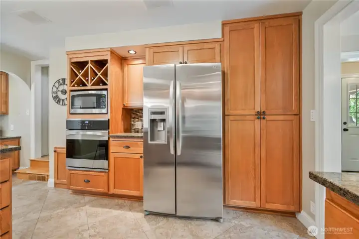 Kitchen with custom wood cabinets, granite countertops, gas range, and stainless appliances Kitchen with custom wood cabinets, granite countertops, gas range, and stainless appliances